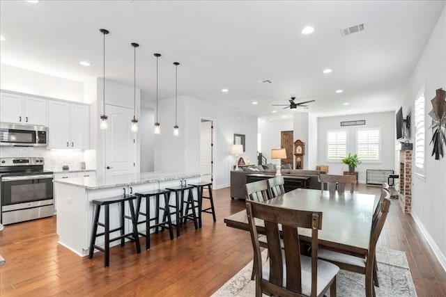 dining area with baseboards, visible vents, a ceiling fan, dark wood-style floors, and recessed lighting