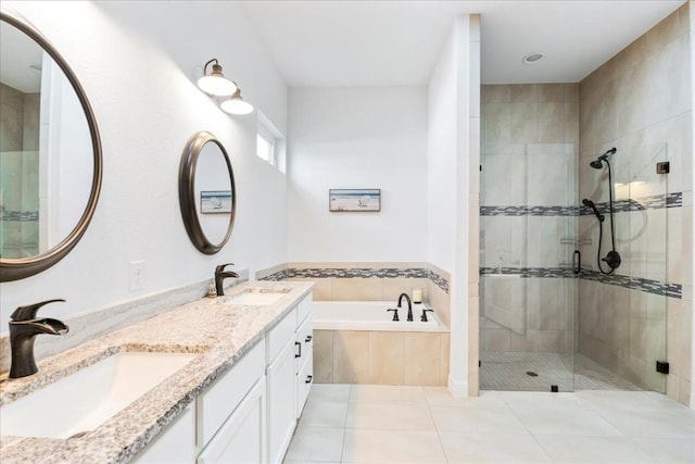 bathroom featuring tile patterned flooring, a garden tub, a sink, and a shower stall