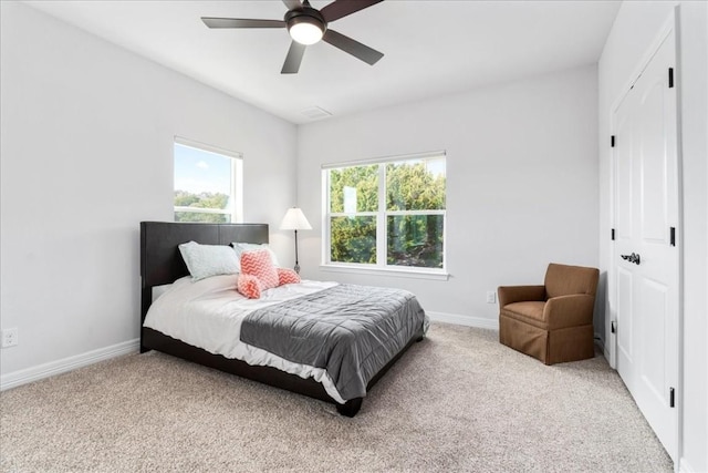 bedroom featuring a closet, light colored carpet, and baseboards