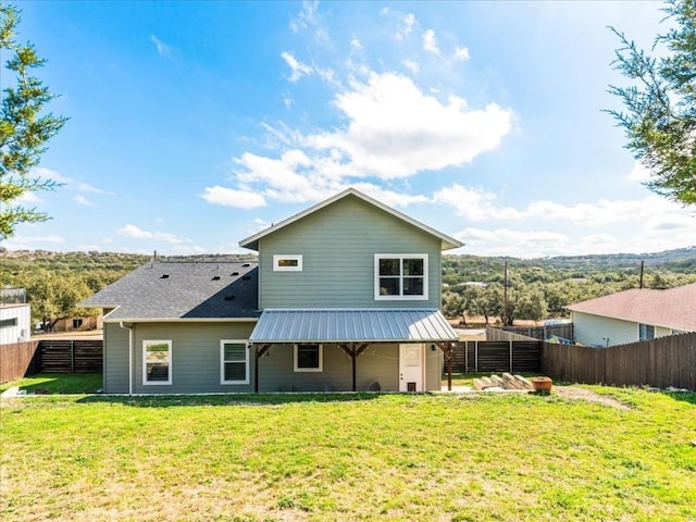 back of property featuring a fenced backyard and a lawn