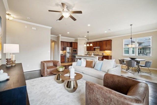 living area with ornamental molding, wood finished floors, baseboards, recessed lighting, and a ceiling fan