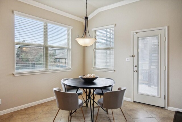 dining room featuring crown molding, light tile patterned flooring, baseboards, and lofted ceiling