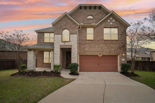 view of front of house with fence, an attached garage, brick siding, a yard, and driveway