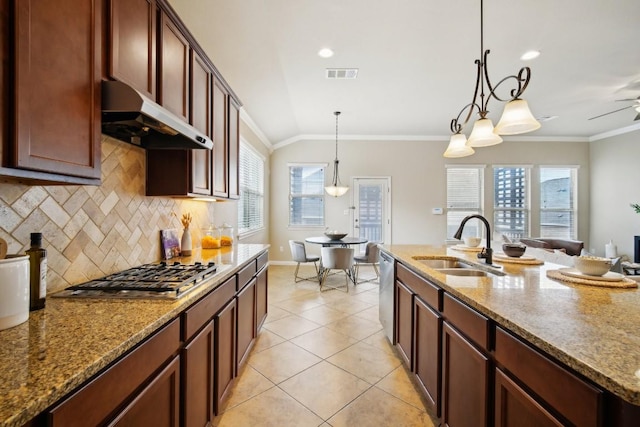 kitchen with appliances with stainless steel finishes, decorative light fixtures, sink, ornamental molding, and light stone countertops