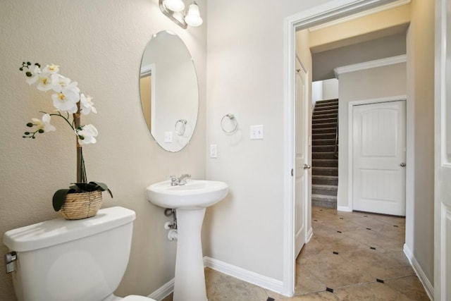 bathroom featuring a sink, tile patterned floors, baseboards, and toilet