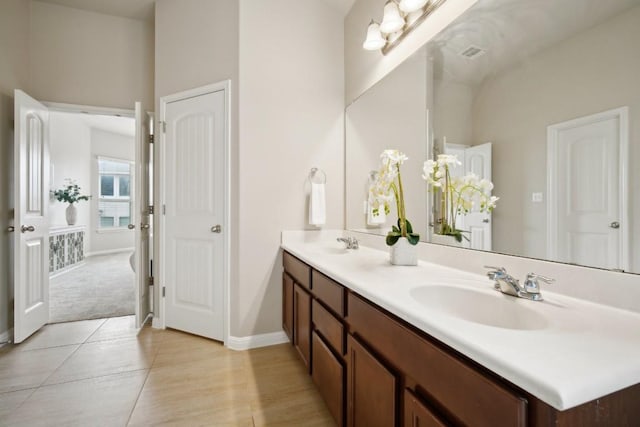 bathroom featuring double vanity, a sink, and baseboards