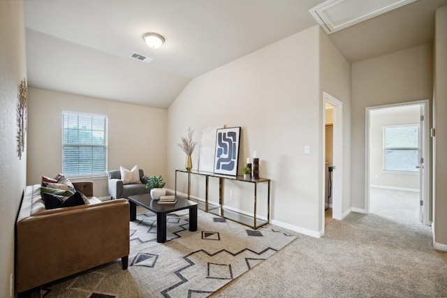 living area featuring carpet floors, attic access, baseboards, lofted ceiling, and visible vents