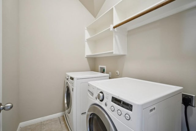 laundry area featuring light tile patterned floors, baseboards, laundry area, and washing machine and dryer