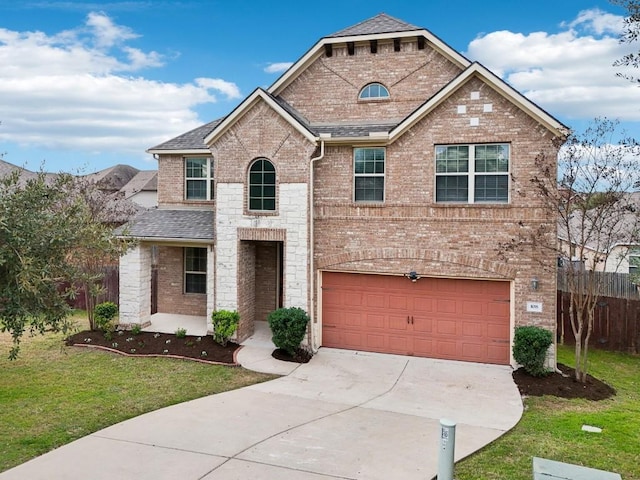 view of front facade with driveway, a front yard, brick siding, fence, and an attached garage