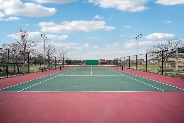 view of tennis court featuring fence and community basketball court