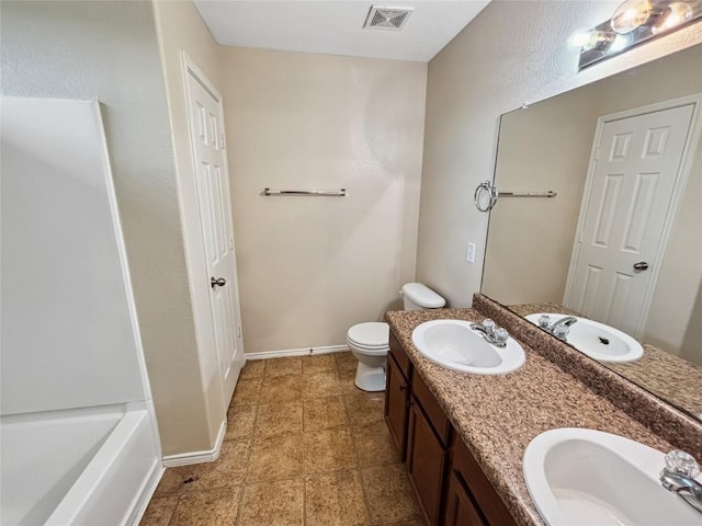 bathroom with vanity, a tub to relax in, and toilet