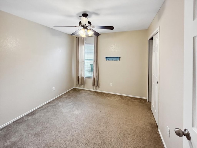 carpeted empty room featuring ceiling fan