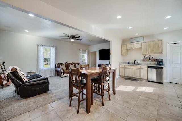 dining room with light carpet, sink, and ceiling fan