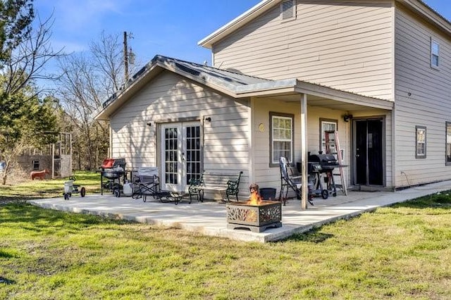 back of property featuring a yard, a fire pit, and a patio