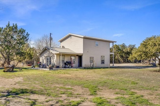 rear view of property featuring a yard