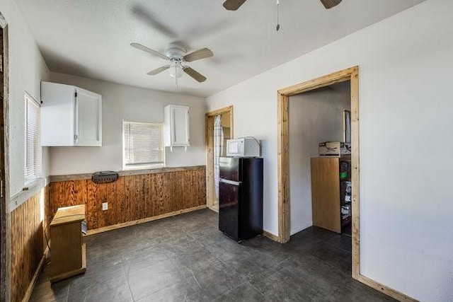 kitchen featuring white cabinetry, black refrigerator, and ceiling fan