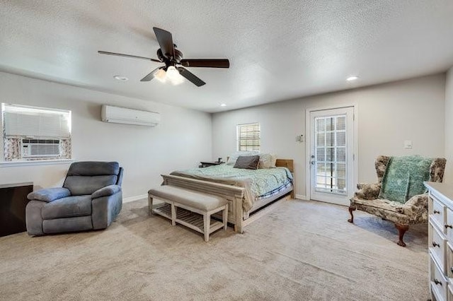 bedroom featuring ceiling fan, a wall mounted air conditioner, a textured ceiling, access to outside, and light colored carpet