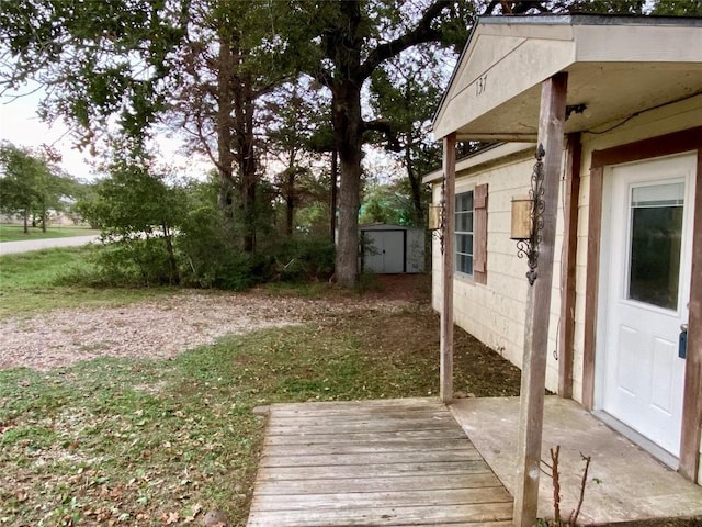 view of yard with a wooden deck and a storage unit