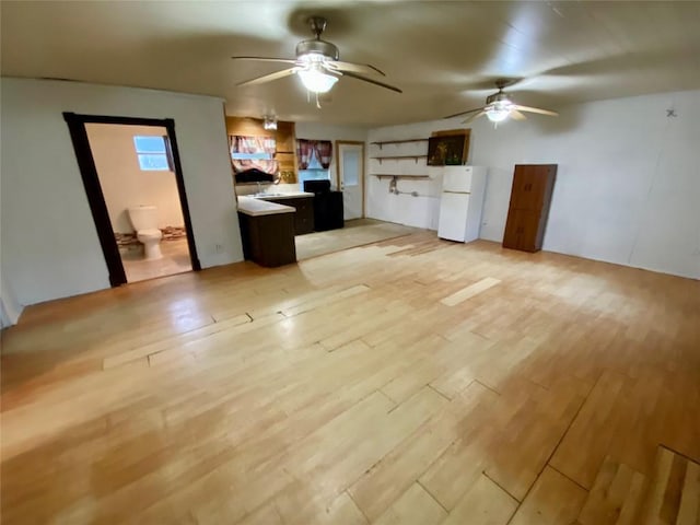 kitchen featuring white refrigerator, ceiling fan, a center island, and light wood-type flooring