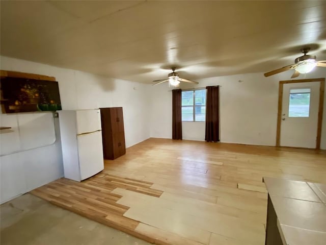 empty room with ceiling fan and light wood-type flooring