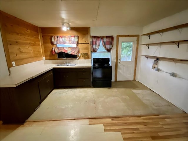 kitchen with black range with electric stovetop, dark brown cabinets, and sink