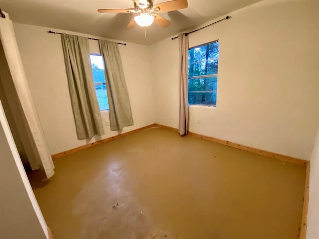 spare room with a water view, ceiling fan, and concrete floors