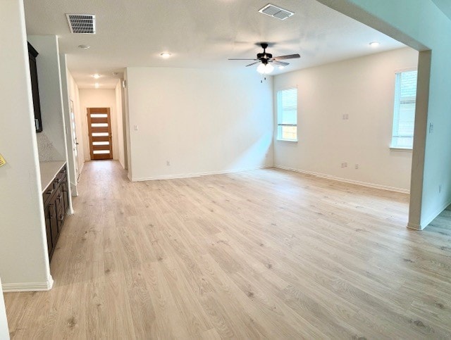 unfurnished living room featuring ceiling fan and light hardwood / wood-style floors