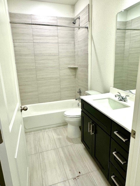 full bathroom featuring tiled shower / bath, vanity, and toilet