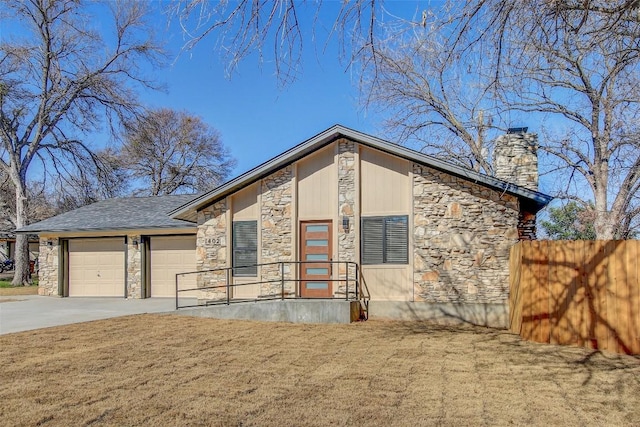 view of front of home with a chimney, stone siding, an attached garage, and concrete driveway