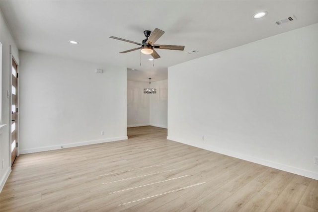 unfurnished room featuring recessed lighting, ceiling fan with notable chandelier, baseboards, and light wood finished floors