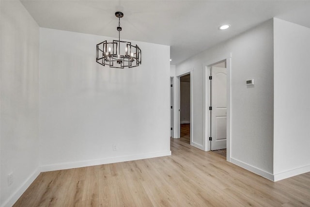 unfurnished dining area featuring a chandelier, recessed lighting, baseboards, and wood finished floors