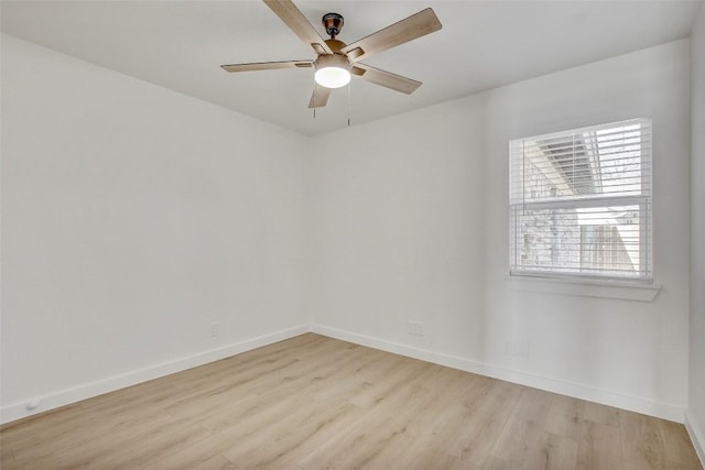 spare room with ceiling fan, baseboards, and light wood-style floors