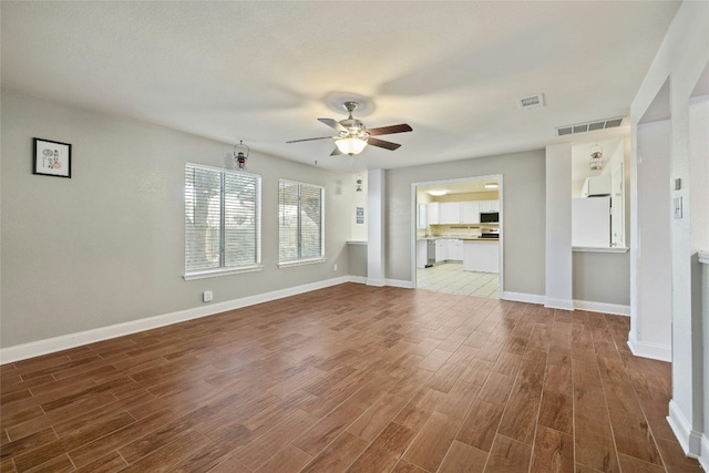 unfurnished living room with hardwood / wood-style floors and ceiling fan