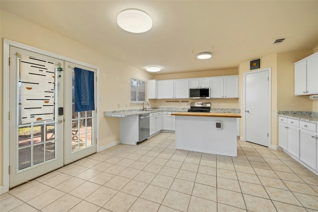 kitchen with stainless steel appliances, a center island, sink, and white cabinets