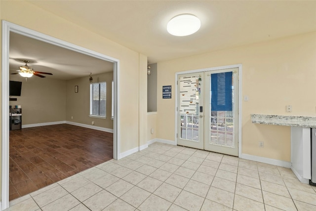 tiled empty room with french doors and ceiling fan