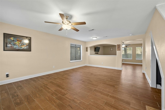 unfurnished living room with ceiling fan and dark hardwood / wood-style flooring