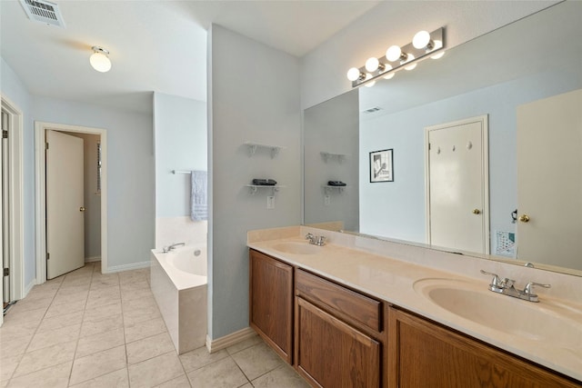 bathroom with tiled tub, vanity, and tile patterned floors