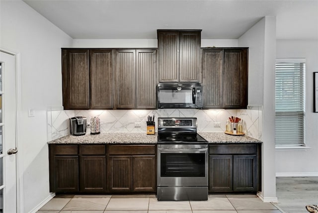 kitchen featuring tasteful backsplash, stainless steel electric range oven, light stone countertops, and dark brown cabinets