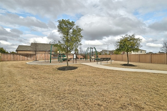 community play area featuring a lawn and fence