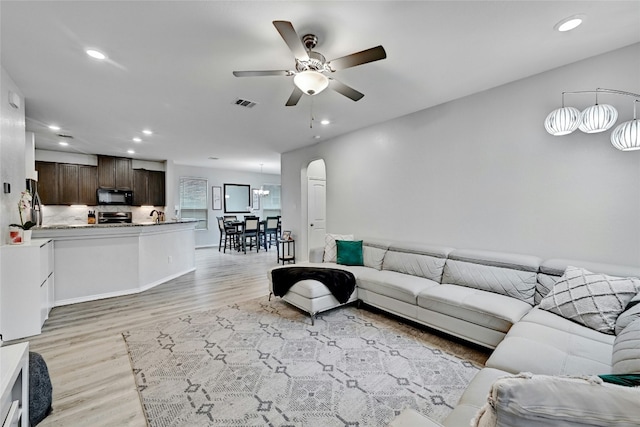 living room featuring ceiling fan and light hardwood / wood-style flooring