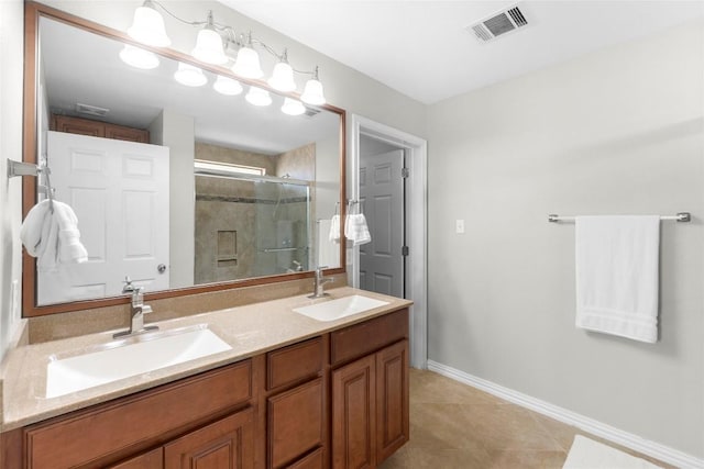 bathroom featuring vanity, a shower with shower door, and tile patterned floors