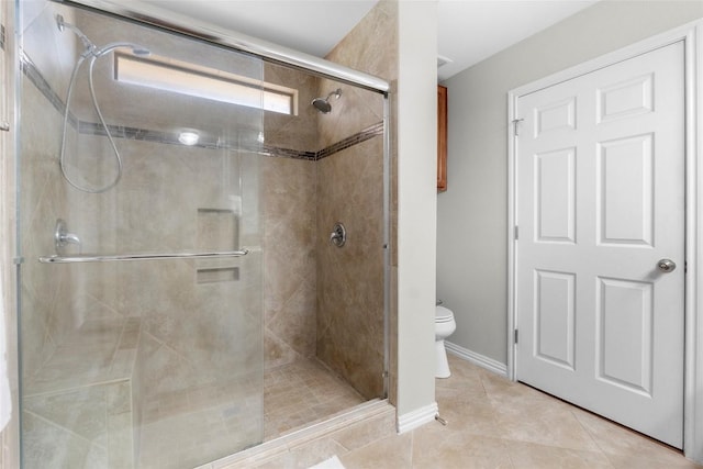 bathroom featuring walk in shower, tile patterned floors, and toilet