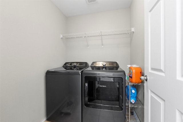 laundry area featuring tile patterned floors and washing machine and dryer