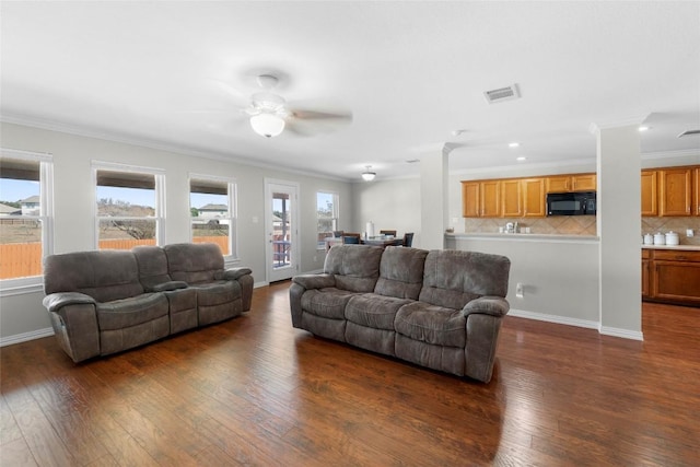 living room featuring ornamental molding, dark wood-type flooring, and ceiling fan