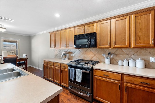 kitchen with tasteful backsplash, sink, crown molding, gas range, and dark wood-type flooring