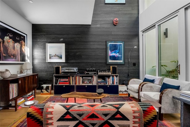 living room with an accent wall and wood finished floors