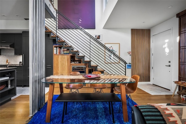 dining area with stairway and wood finished floors