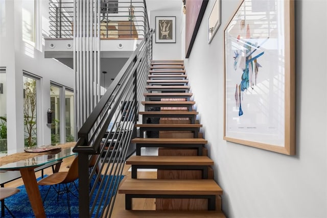 staircase with a wealth of natural light and a high ceiling