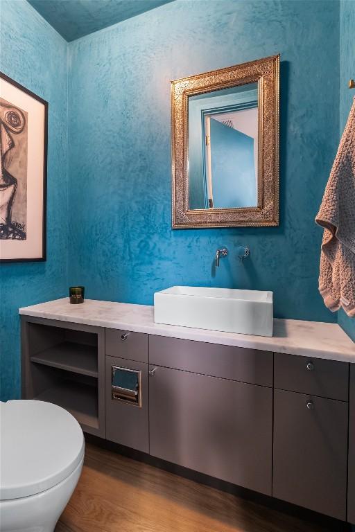 bathroom featuring vanity, toilet, and wood finished floors