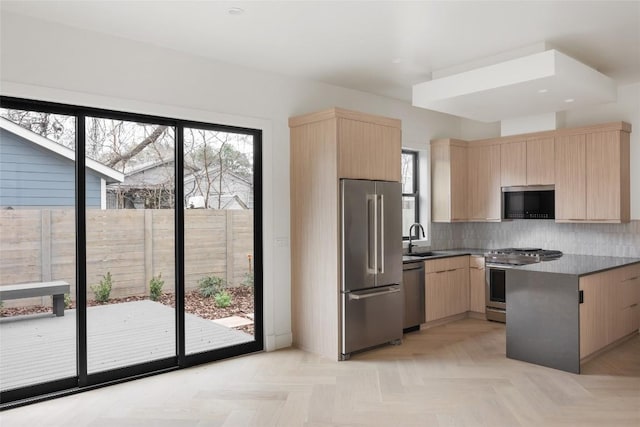 kitchen featuring sink, stainless steel appliances, decorative backsplash, light parquet flooring, and light brown cabinets